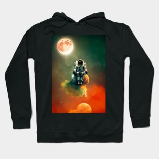 Astronaut sitting on a moon with red clouds in space with moons in the background Hoodie